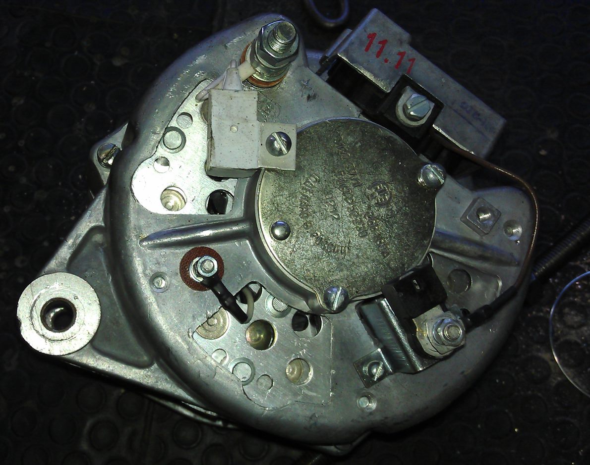 Rear of an automotive alternator showing the output terminal stud and regulator pack