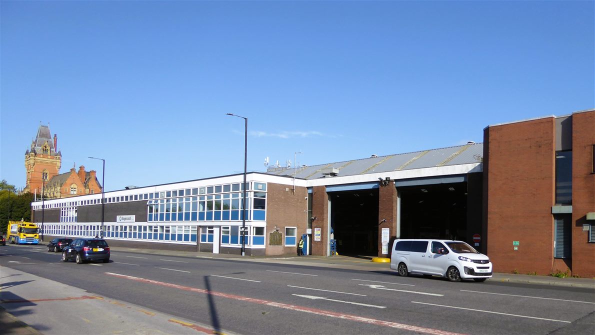 A bus depot building with open vehicle bays