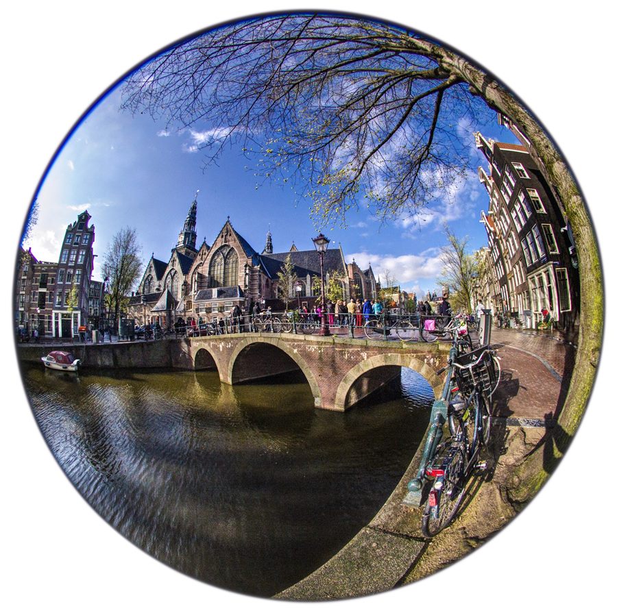 A circular fisheye photograph with strongly curved buildings and bridge