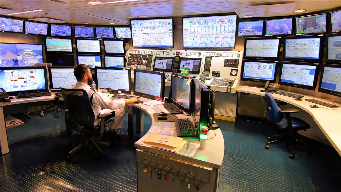 An engine control room with many screens and an operator