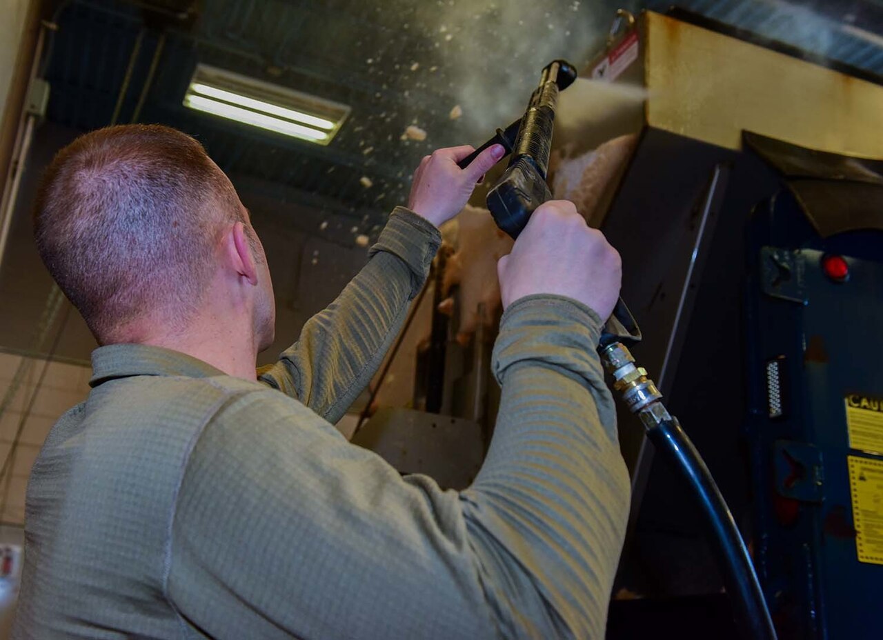 High-pressure water jet cleaning a vehicle at close range