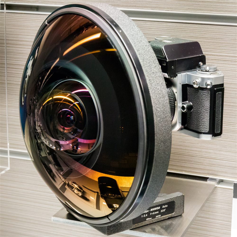 Large fisheye lens mounted on a camera body, dome front element facing the viewer