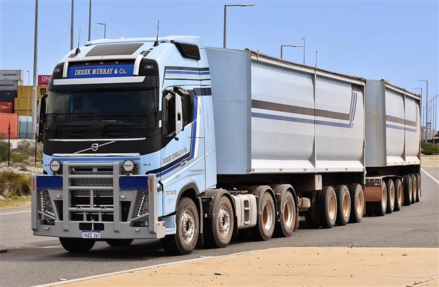 A blue Volvo FH16 articulated truck seen from the front and side on a road