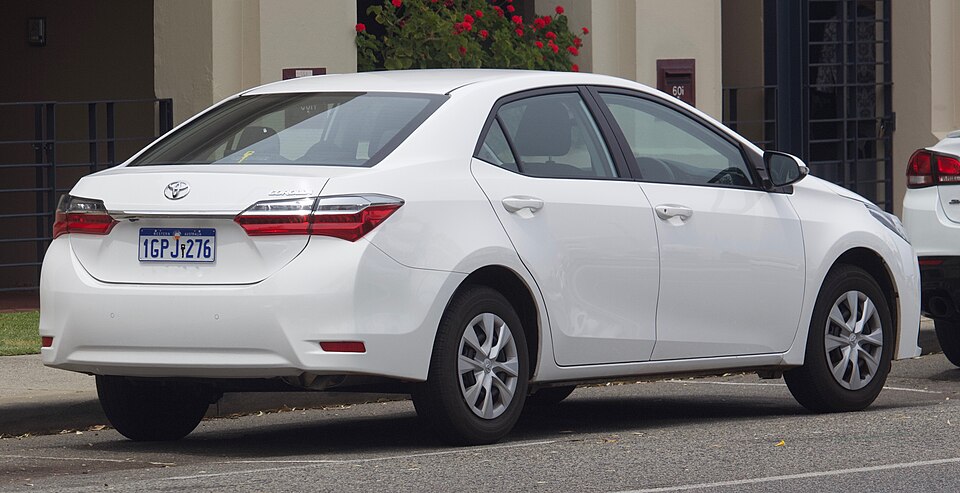 A white Toyota Corolla sedan parked on a street, a modern passenger car