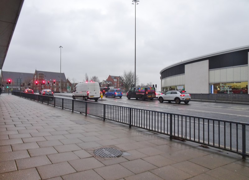 Commercial vans and cars on a wet road in dull, rainy weather