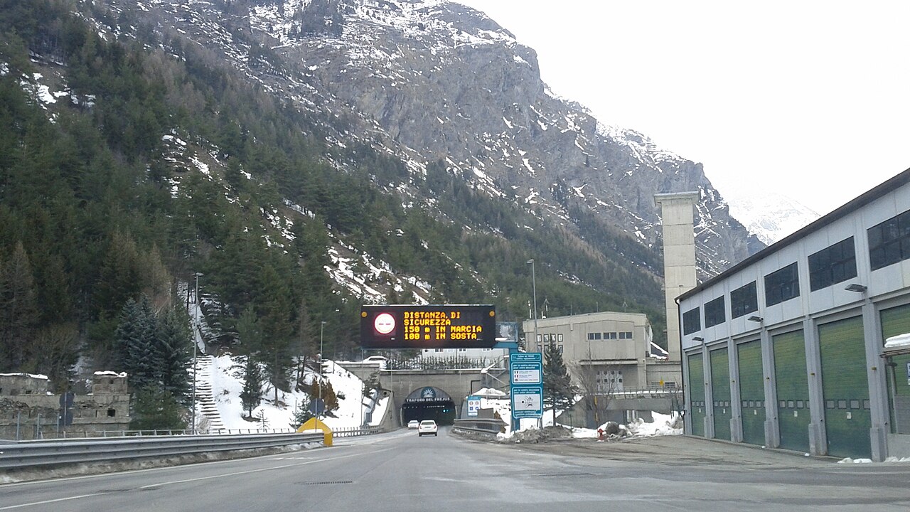 A vehicle on a mountain motorway approaching the portal of the Frejus road tunnel