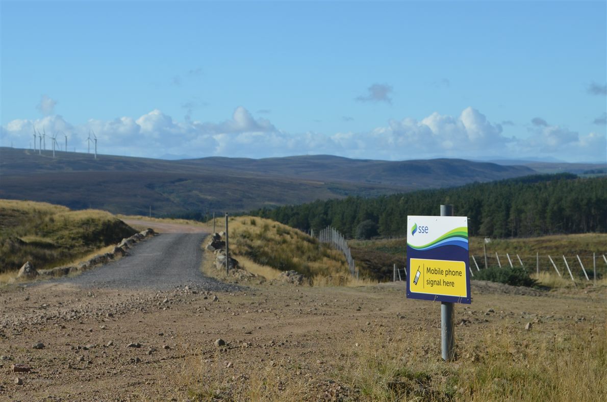 A sign reading mobile phone signal here on a remote track
