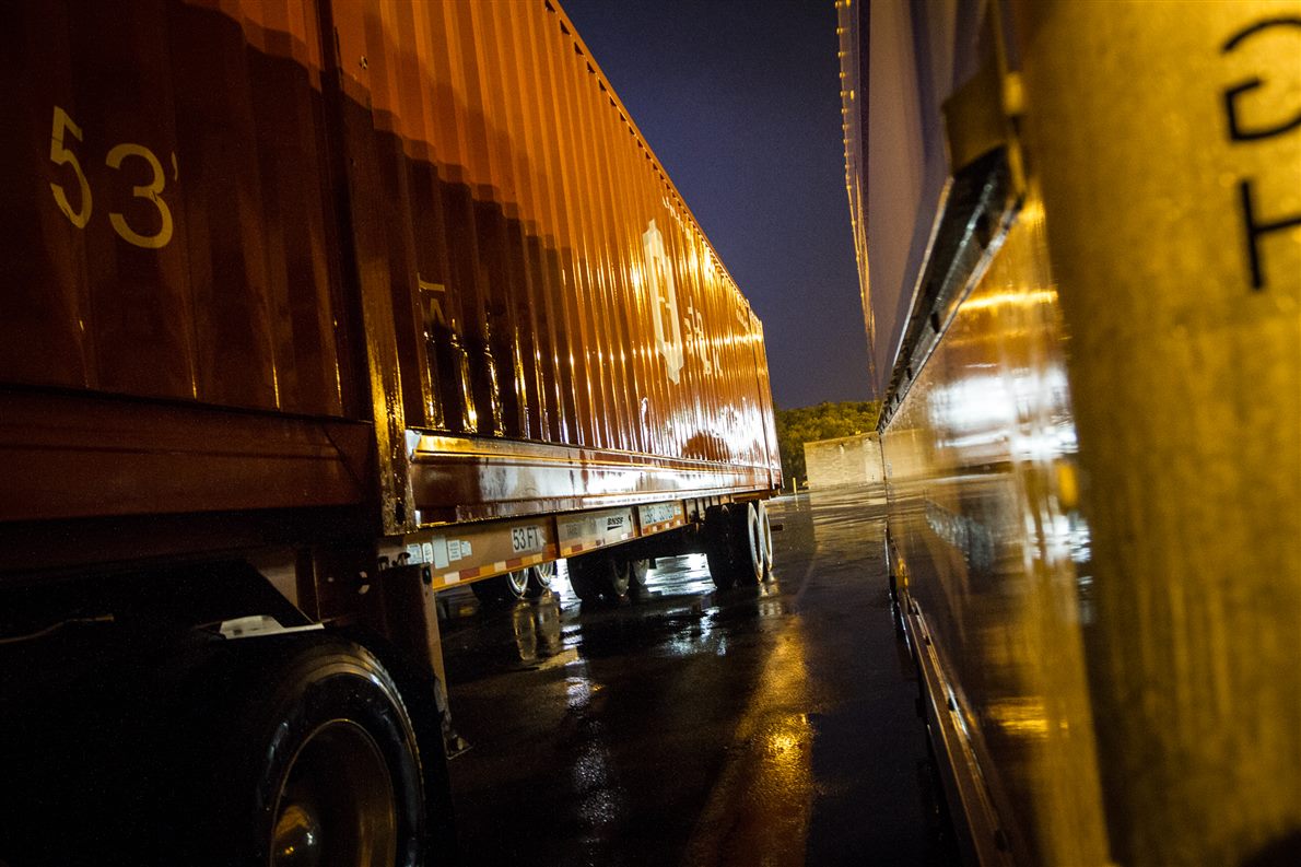Parked trailers at a rainy truck stop at night