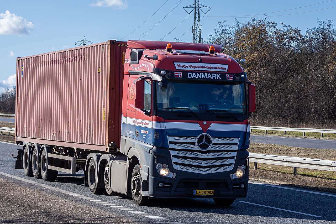 Red and blue Mercedes Actros container lorry on the road