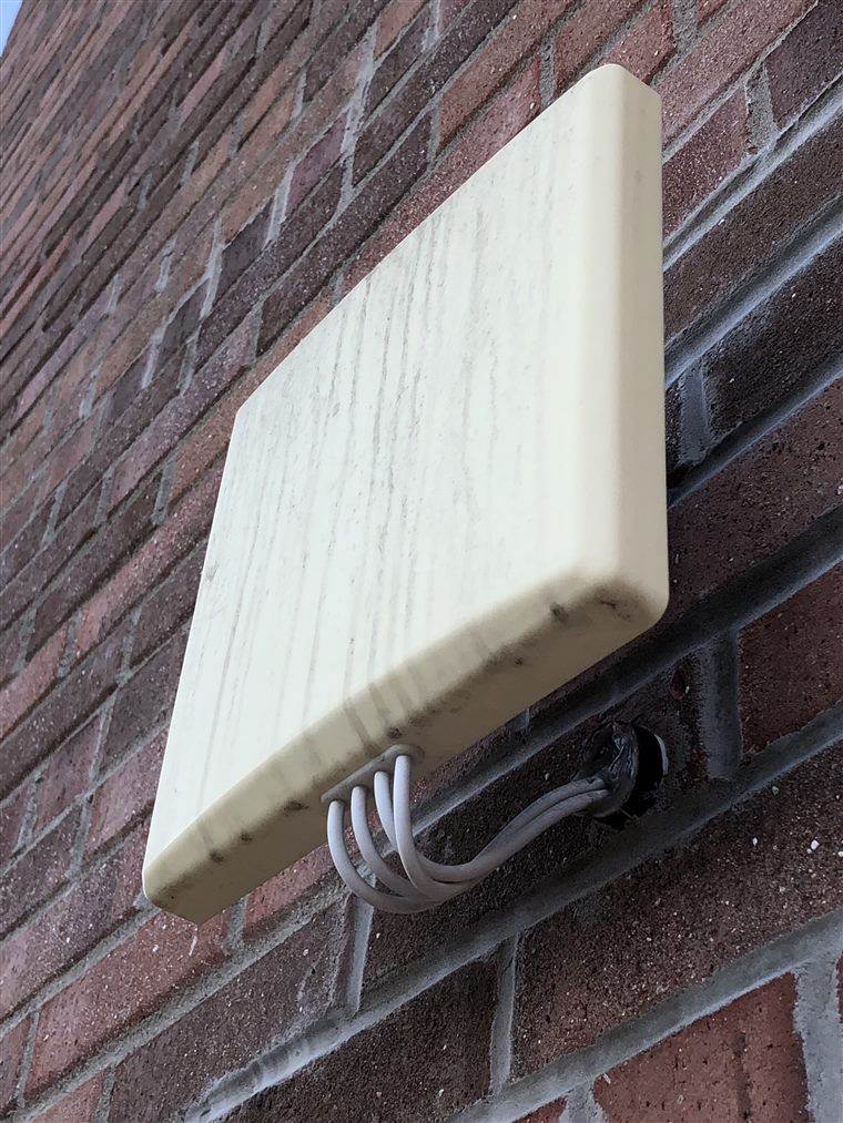 An outdoor wireless access point mounted on a brick wall