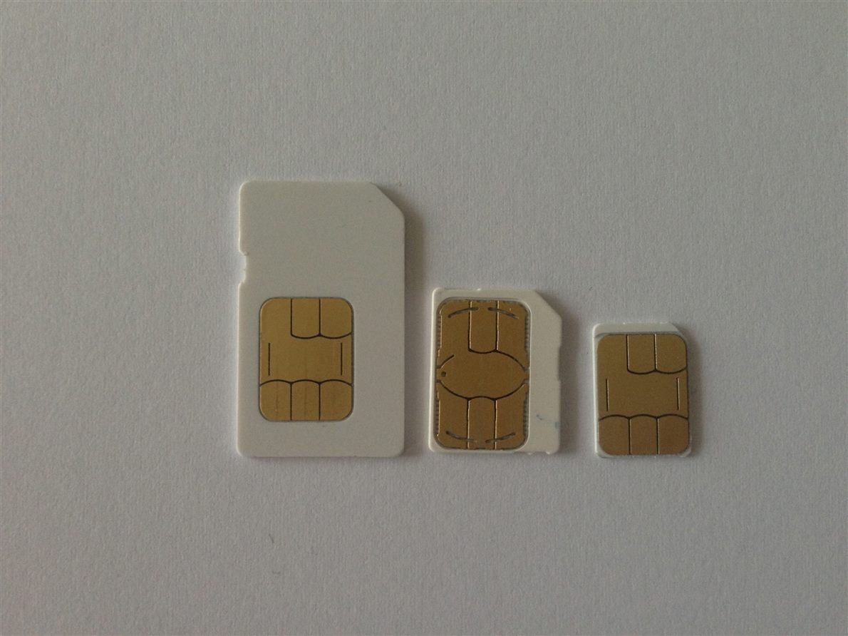 SIM cards of several formats on a plain surface