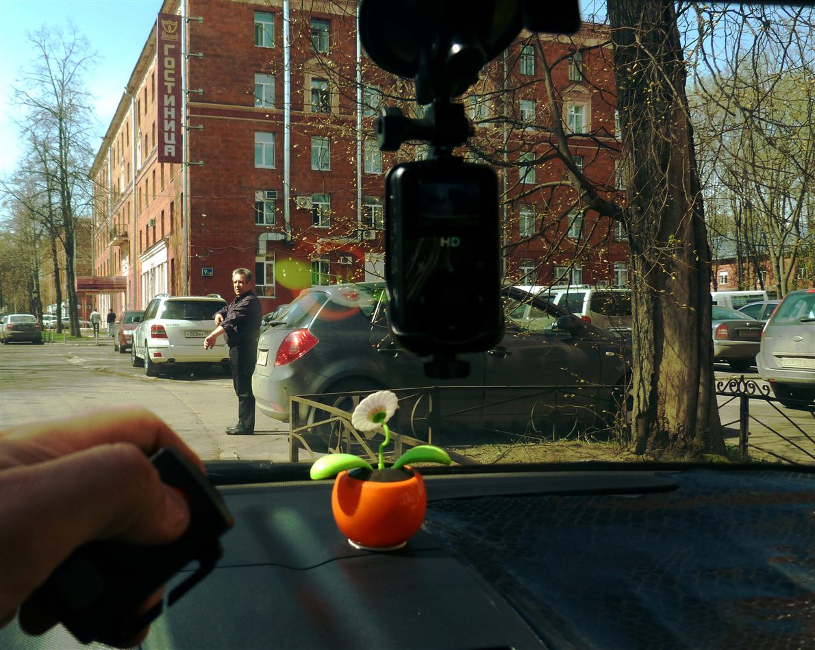 Dashcam mounted on a windscreen with the street visible through the glass